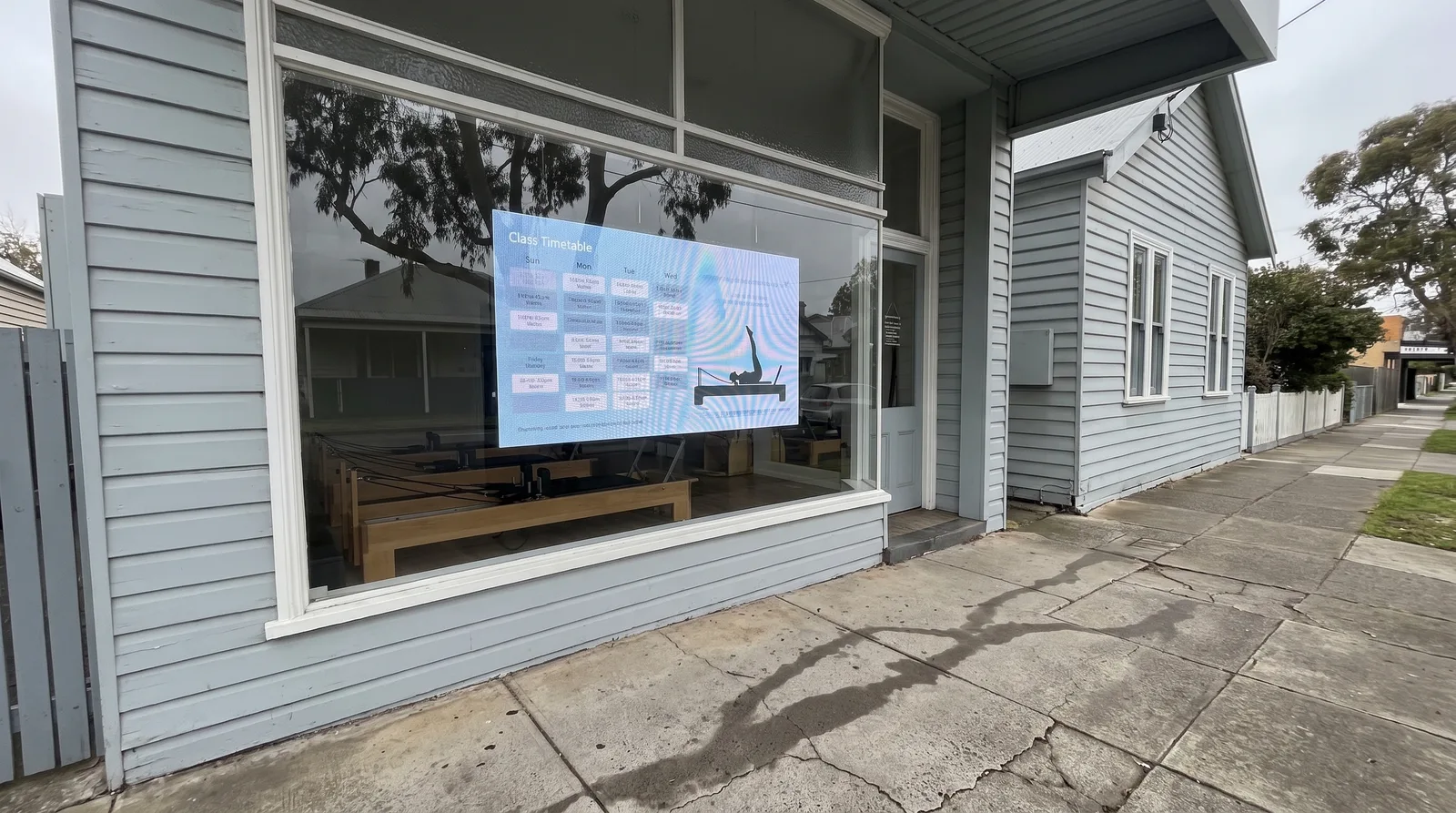 Pilates studio window with class timetable on transparent screen